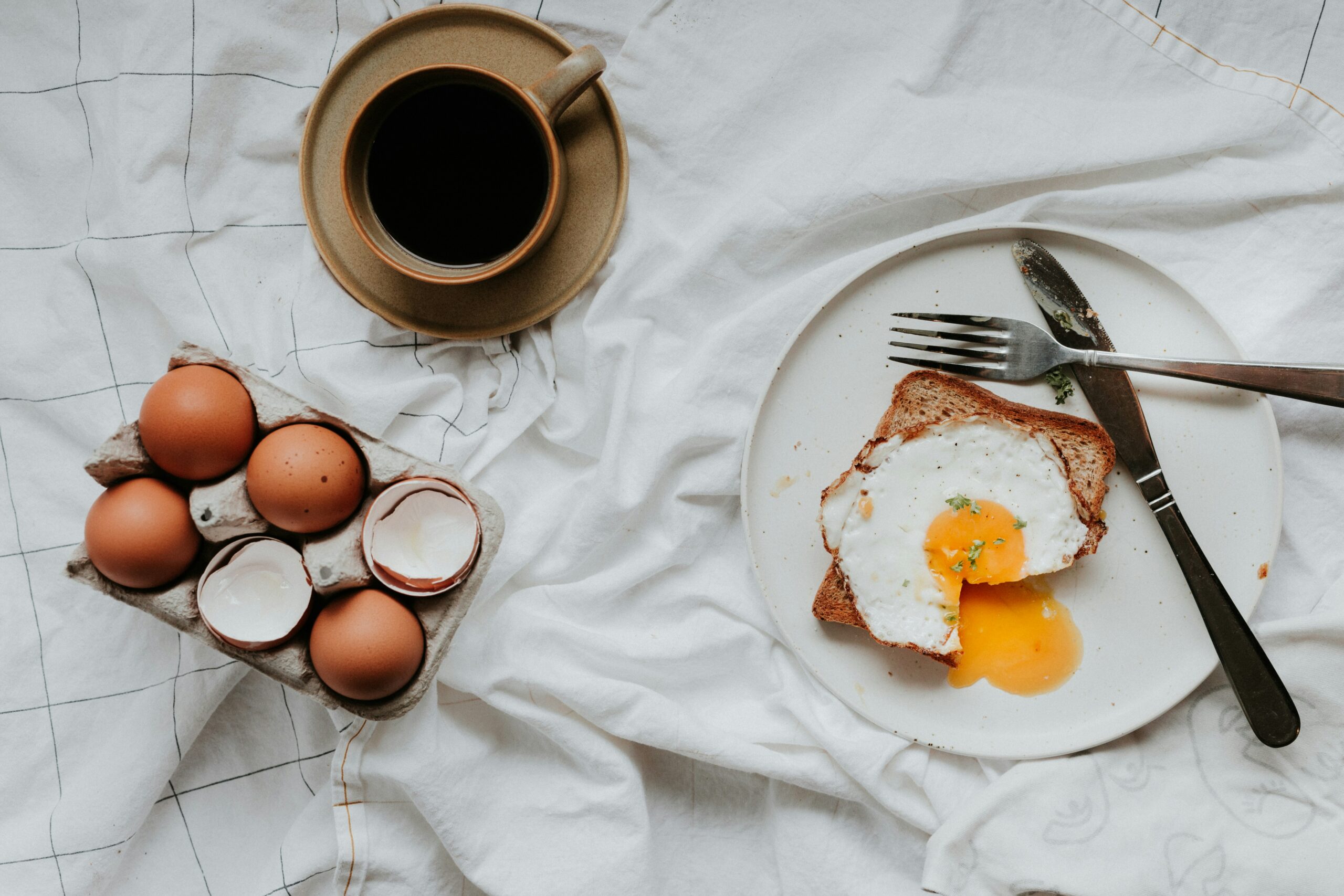 Eggs and toast breakfast on a white table (high-protein foods post)